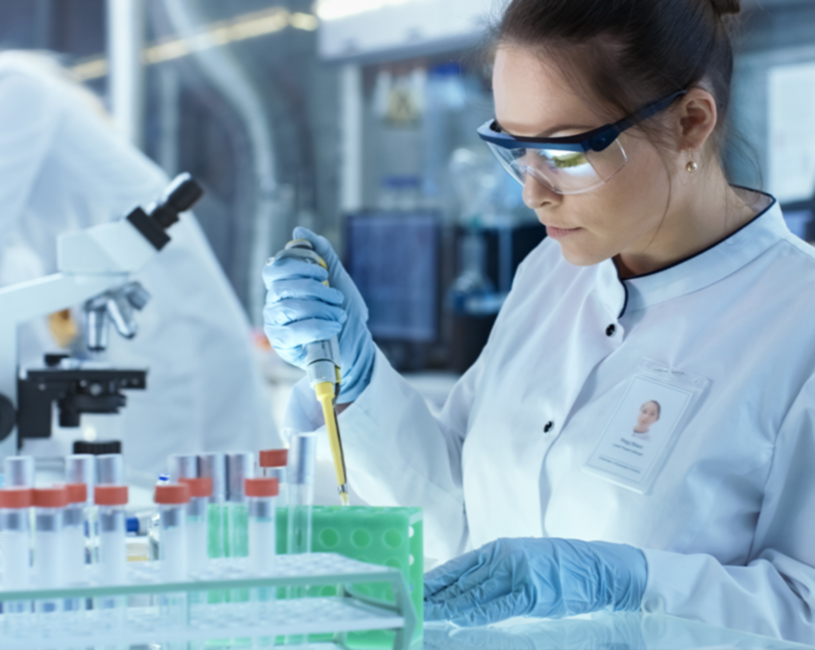 Lab profesionally using pipette and wearing goggles